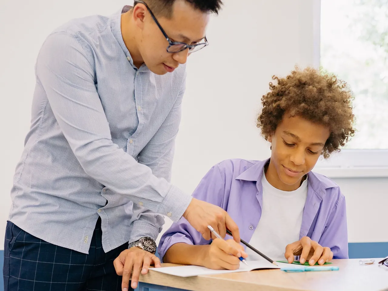 An Edugro tutor checking a student's working during a class
